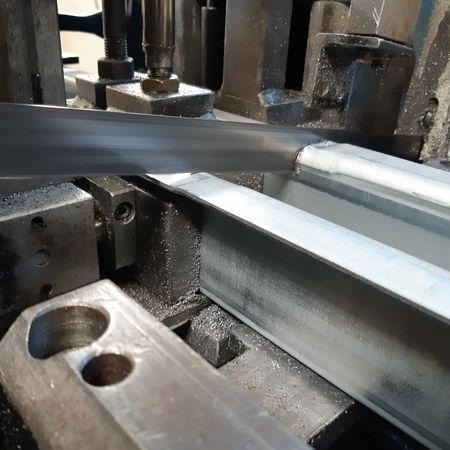 Eine Maschine schneidet Metallstangen in einer Fabrik, um präzise Teile für die Produktion herzustellen.